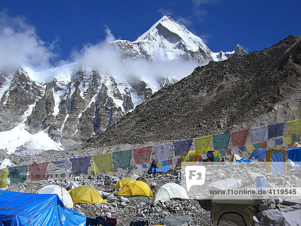 Tibetische Gebetsfahnen zwischen Zelten im Mount Everest Basislager  5300m  Hintergrund der Gipfel des Lingtren  6600m  Himalaya  Nepal
