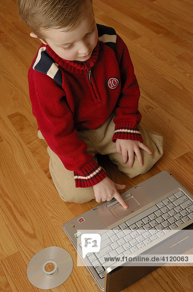 Young boy (age 5) working on a latop computer