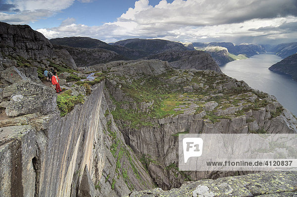 Tourists standing on Preikestolen cliff above Lysefjord  Rogaland  Norway  Scandinavia  Europe