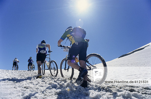 Mountainbiker im Schnee bei der Transalp Challenge  Pfunderer Joch  Südtirol  Italien  Europa