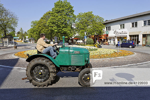 Mann fährt auf altem Traktor im Kreisverkehr  Leobersdorf  Niederösterreich  Österreich