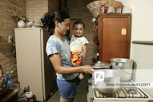 Woman with toddler cooking  Comunidad 18 de Agosto  Paraguay  South America