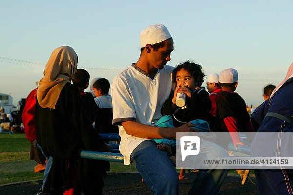 Father and son on roundabout  Islamic festival  Cape Town  South Africa