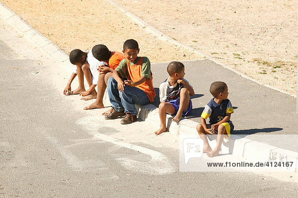 Children sitting at the roadside in a township  Cape Town  South Africa