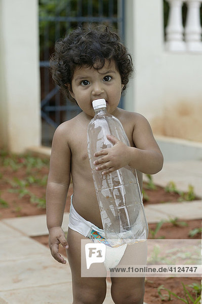 Kleinkind zahnend  mit Wasserflasche  Asuncion  Paraguay  Südamerika