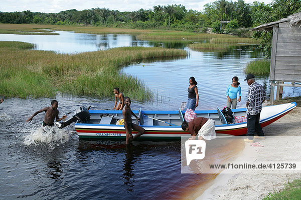 Boat with people at the bank of Lake Capoey  Guyana  South America