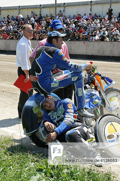 Sidecar motorcycle driver taking a break at an international motorcycle race on a dirt track speedway in Muehldorf am Inn  Upper Bavaria  Bavaria  Germany  Europe