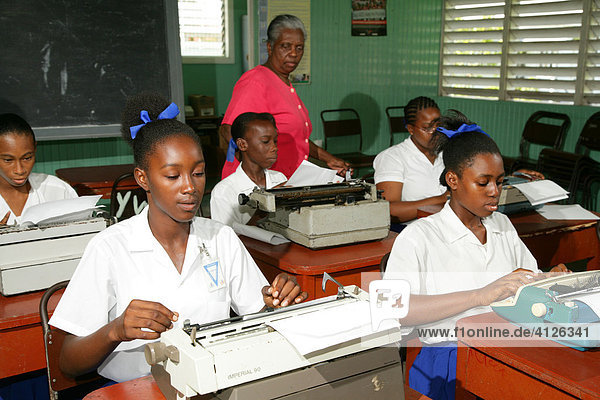 Girls wearing school uniforms in typing class at a training centre for young women in New Amsterdam  Guyana  South America