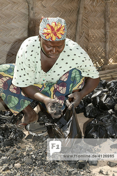 Frau verpackt Holzkohle für den Verkauf  Garoua  Kamerun  Afrika