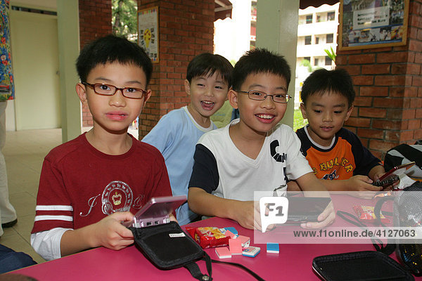 Boys playing Gameboy  Singapore  Southeast Asia