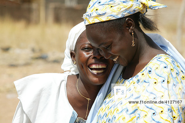 Two women laughing during a church service  Garoua  Cameroon  Africa