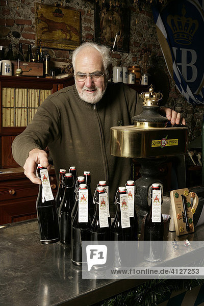 Senior citizen filling beer bottles in a brewery museum in Muehldorf am Inn  Bavaria  Germany  Europe
