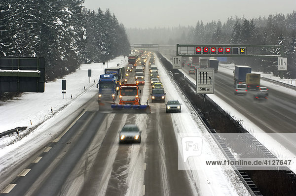 Highway at wintry road conditions traffic jam on the higway snowplough cleaning the highway