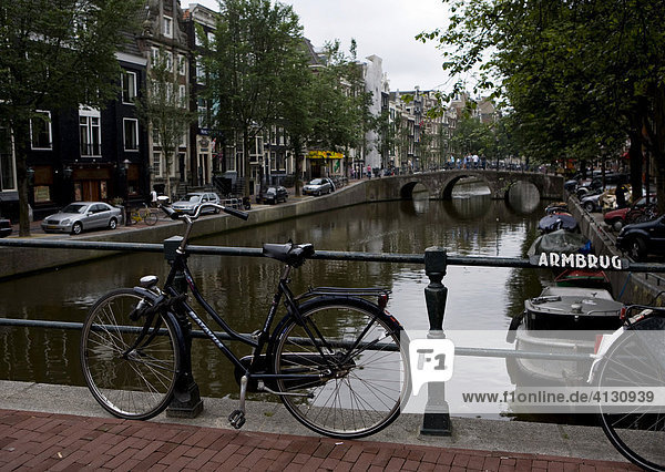 Fahrrad parkt auf Brücke an einer Gracht. Amsterdam  Niederlande.