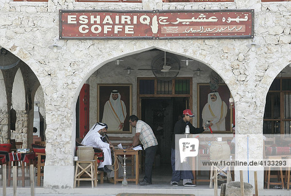 Qatar  Katar  Doha  Männer sitzen vor einem Cafe und rauchen Wasserpfeife  Shisha.