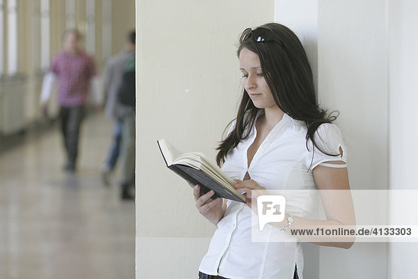 Junge Frau in der Uni mit einem Buch