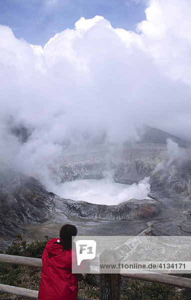 A woman looks into the main crater of the volcano Poas  Costa Rica  Central America