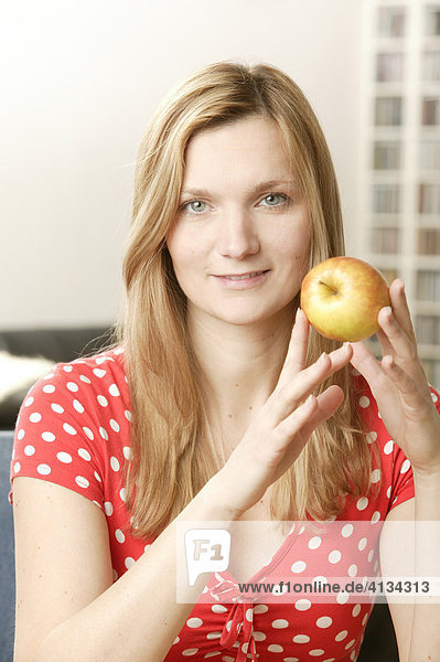 Junge blonde Frau mit Apfel