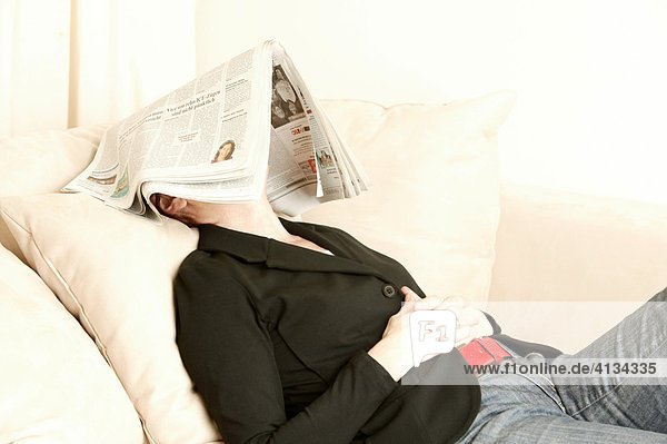 Frau im mittleren Alter mit Zeitung auf dem Kopf