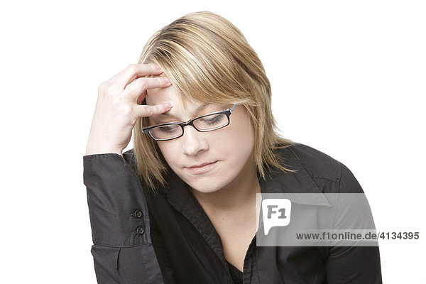 Junge blonde Frau mit Brille fasst sich an den Kopf
