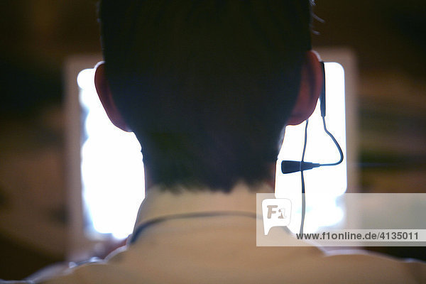 DEU  Bundesrepublik Deutschland : Mann telefoniert mit Headset  Kopfhörer  Hörsprechgarnitur vor Computerbildschirm