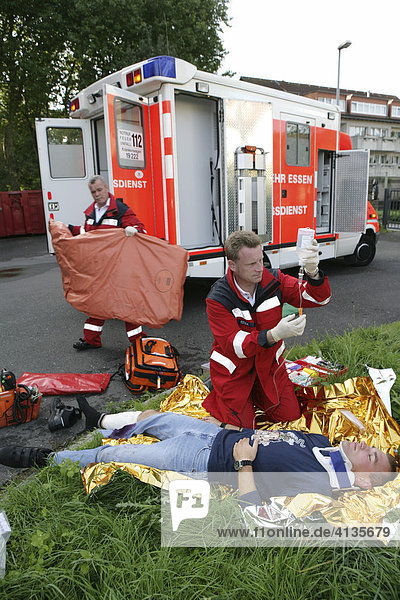DEU Germany : Rescue paramedics first aid after an accident with a man injured at his leg. ambulance fire service. Training situation. |
