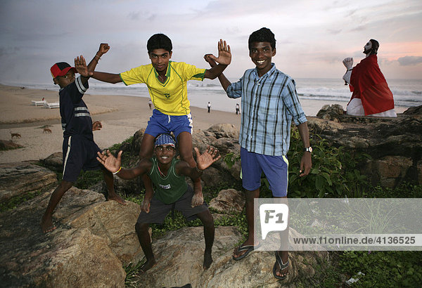 |IND  India  Kerala  Trivandrum : Malabar coast  south of Trivandrum  teenager at the beach. Jesus statue at the beach  near a little pilgrimage chapel. |