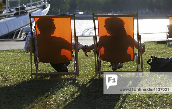 Paar Mann und Frau liegen in Liegestuhl in der Sonne Silhoutte