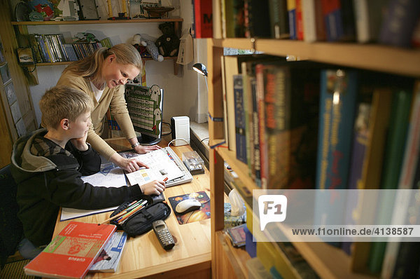 DEU  Germany: Mother is helping her son with homework for school.