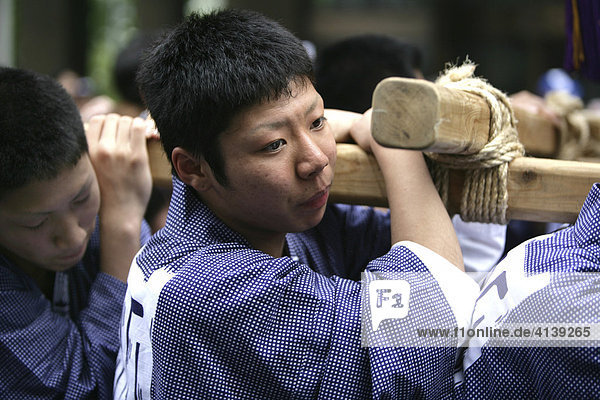 Japan Tokyo: Shrine festival called Matsuri. The Shinto shrines are carried through the streets of the Shinto temple district. Local people carrying the shrine on their shoulders dressed in happi-coats religious festival