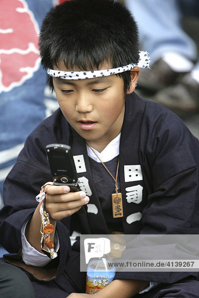 Japan  Tokyo: child with mobile phone during the Shrine festival  called Matsuri