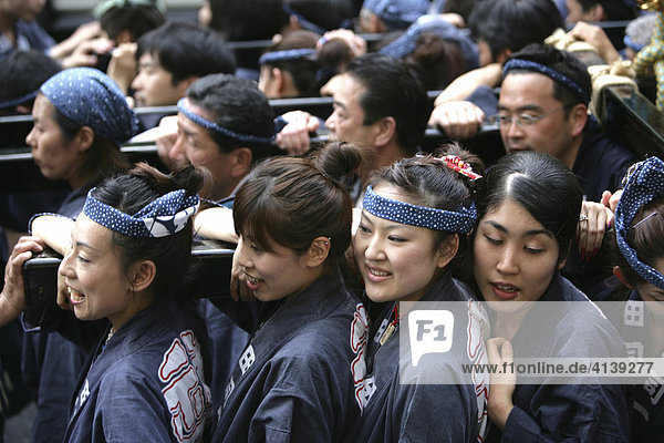 Japan  Tokyo: Shrine festival  called Matsuri. The Shinto shrines are carried through the streets of the Shinto temple district. Local people carrying the shrine on their shoulders  dressed in happi-coats  religious festival