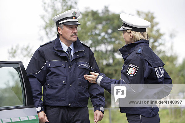 Police officers in front of a police car  new blue police uniforms worn by 1400 male and female North Rhine-Westphalian police officers  Duesseldorf  North Rhine-Westphalia  Germany  Europe