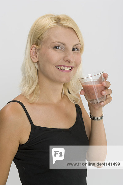Junge Frau trinkt Fruchtsaftmix