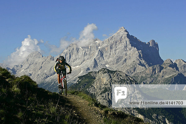 Female mountain biker on the Forcella-Ambrizzola track  with Civetta in the background  Dolomites  Italy