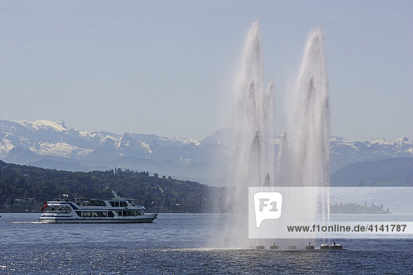 Water fountain in Zurich lake with excursion boat and Alp panorama  near Zurich  Switzerland