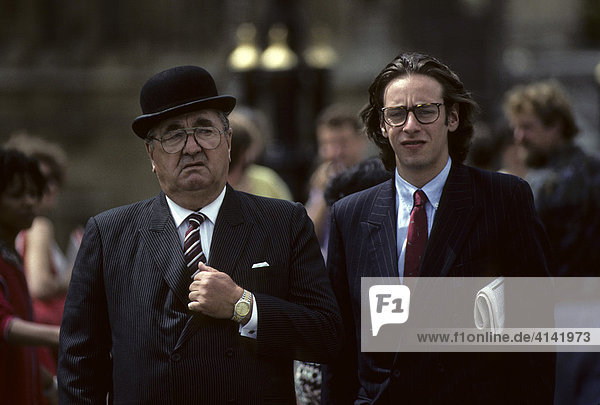 älterer Mann mit Bowler und junger Mann mit Zeitung im Nadelstreifenanzug  London  England  Großbritannien