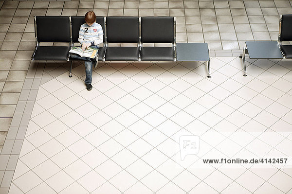 Boy waits in an airport waiting hall