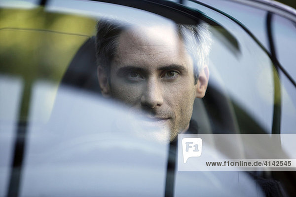 Portrait of a man in a black convertible  seen through the windscreen