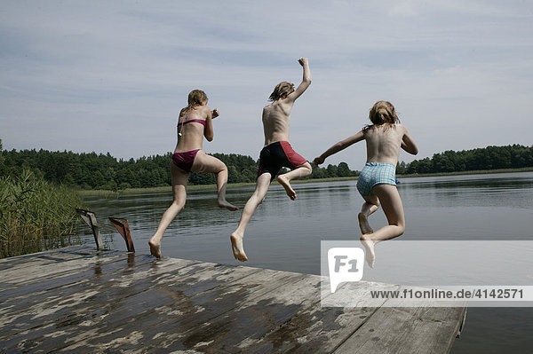Children jumping into a lake in Mecklenburg-Vorpommern  Germany