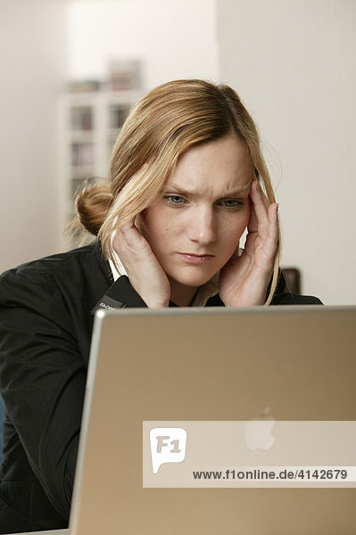 Blonde Frau mit Laptop  gestresst