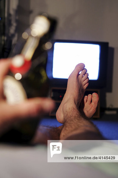 DEU  Germany : man in front of an TV. Bottle of beer.