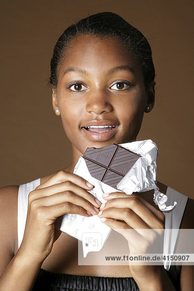 Dark-skinned girl with chocolate bar