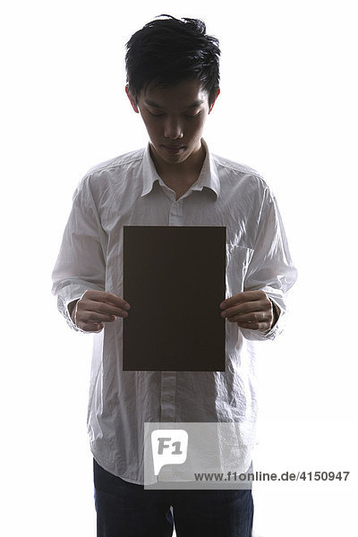 Man holding sheet of paper in his hands