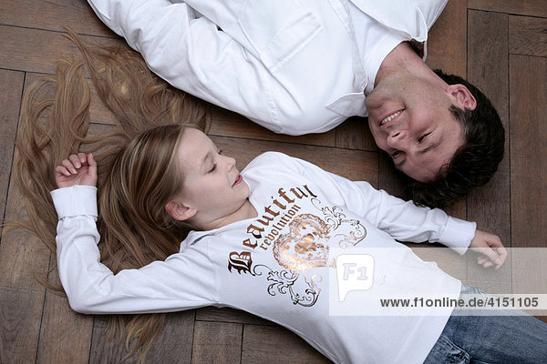 Vater und Tochter liegen auf dem Boden