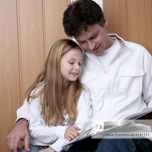 Vater und Tochter lesen in einem Buch