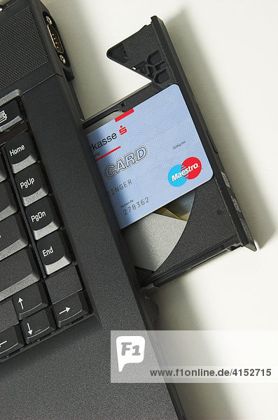 Online Banking  eine ec-Karte ragt aus dem CD-Laufwerk eines Notebook Computers