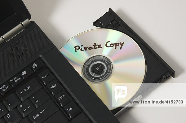 Eine CD mit der Aufschrift Pirate Copy liegt im CD Laufwerk eines Notebook Computers