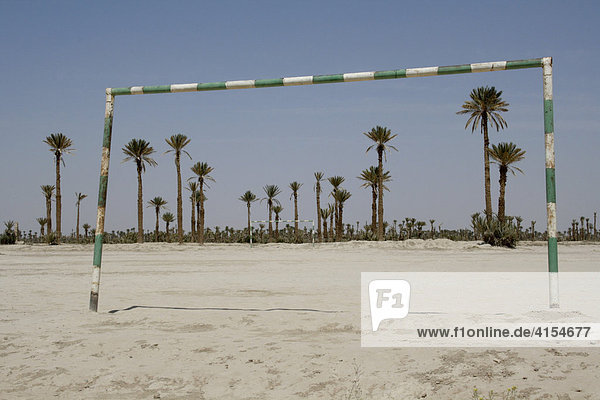 Sandiges Fußballfeld vor Palmen  Rissani  Marokko.
