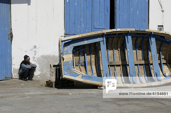 Fischer im Hafen neben Fischerboot  Essaouira  Marokko